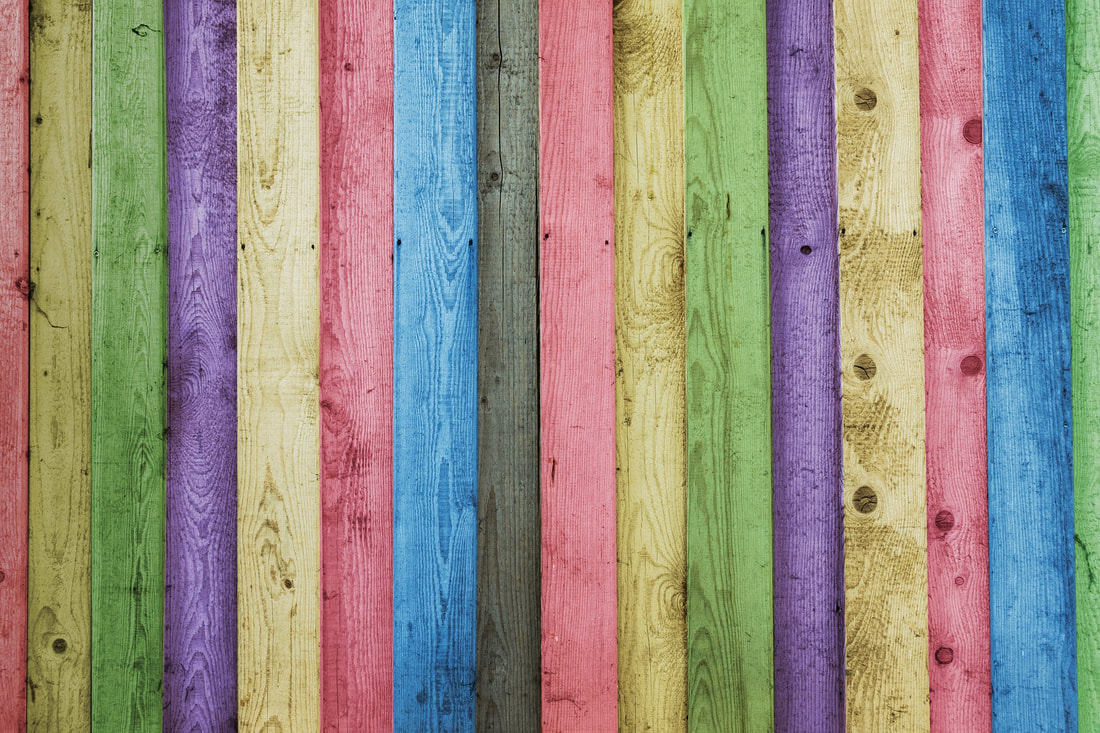 Picture of fence panels painted in different playful colours, like you would see in a kids play area.